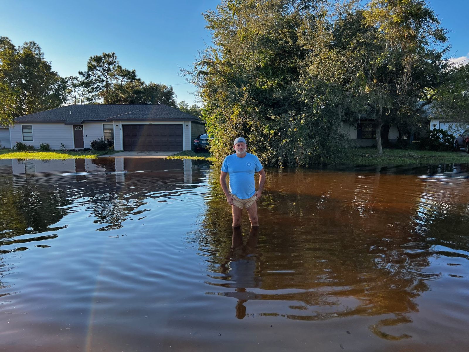 A Deltona resident standing in floodwater in his front yard after Hurricane Ian